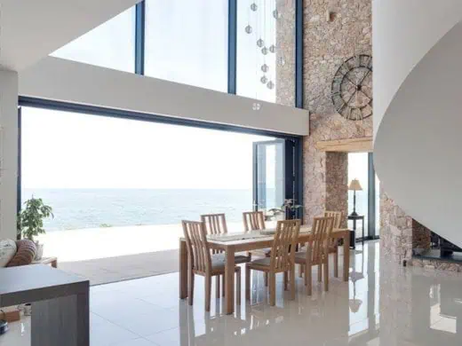 Open aluminium bi-fold doors Huntingdon with views of the sea - Wymondham Windows